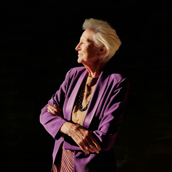 Side profile of woman stretching her arms upwards gracefully